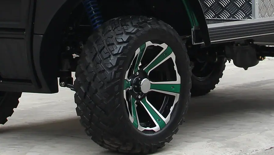 Close-up of Tara golf cart tire with deep off-road tread pattern, designed for superior traction on dirt and grass